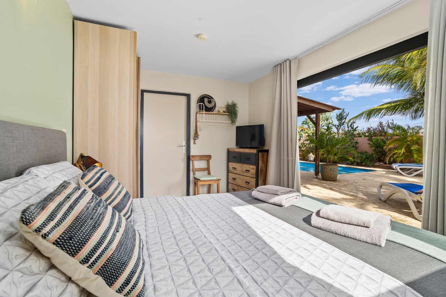 Deluxe Suite at Oasis Guesthouse Bonaire with queen-size bed and seating area