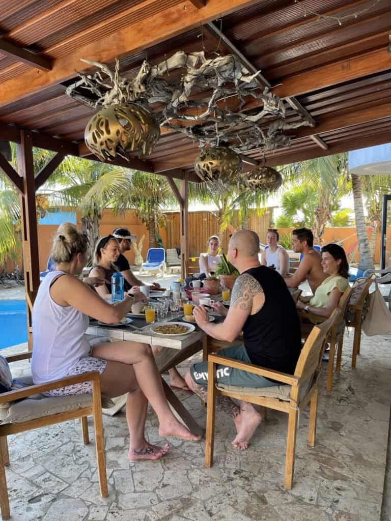 Guests dining together in the communal outdoor area at Oasis Guesthouse Bonaire