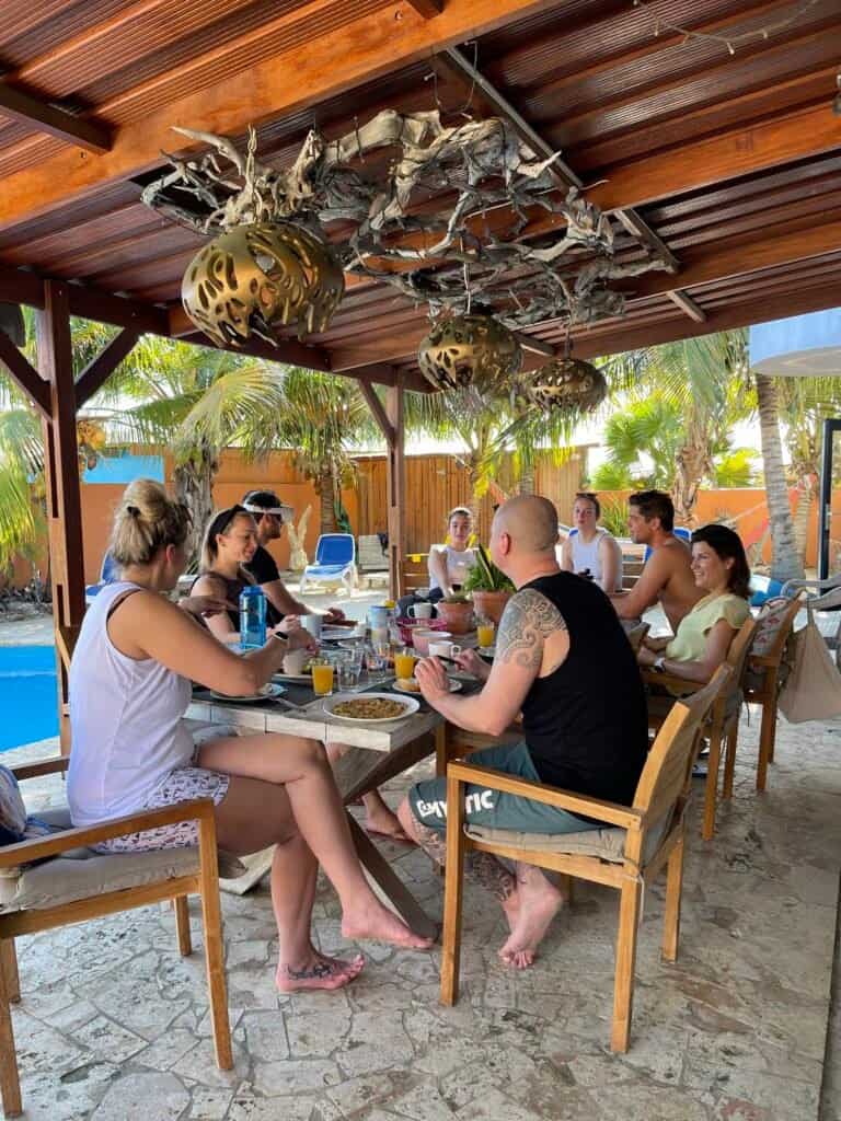 Guests relaxing and socializing around the table at Oasis Guesthouse Bonaire