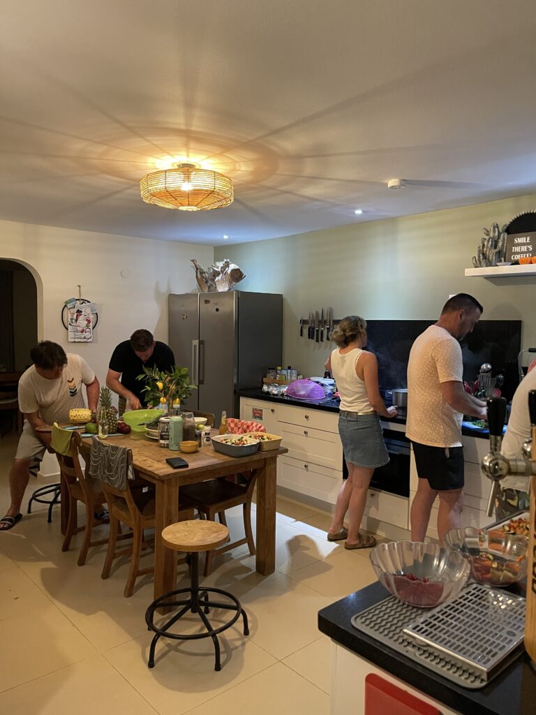 Guests cooking and adding personal touches to the tropical BBQ at Oasis Guesthouse Bonaire